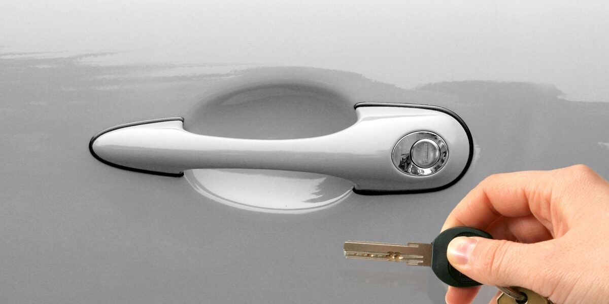 Uninsured motorist putting a key into a car door lock - Spencer Injury Law