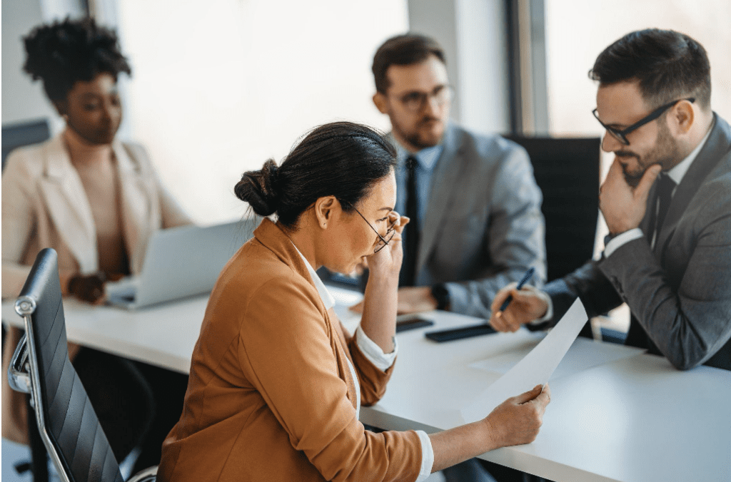 Diverse professionals reviewing documents together in a focused office meeting.